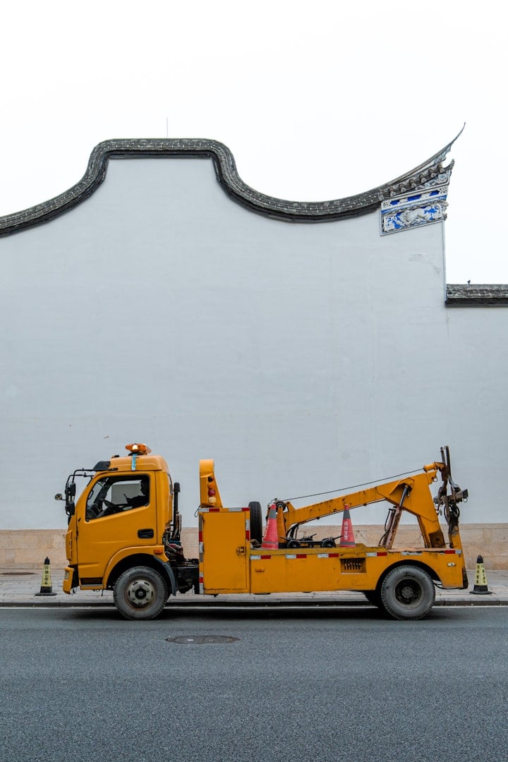 A truck with a tarp on the back driving down a street